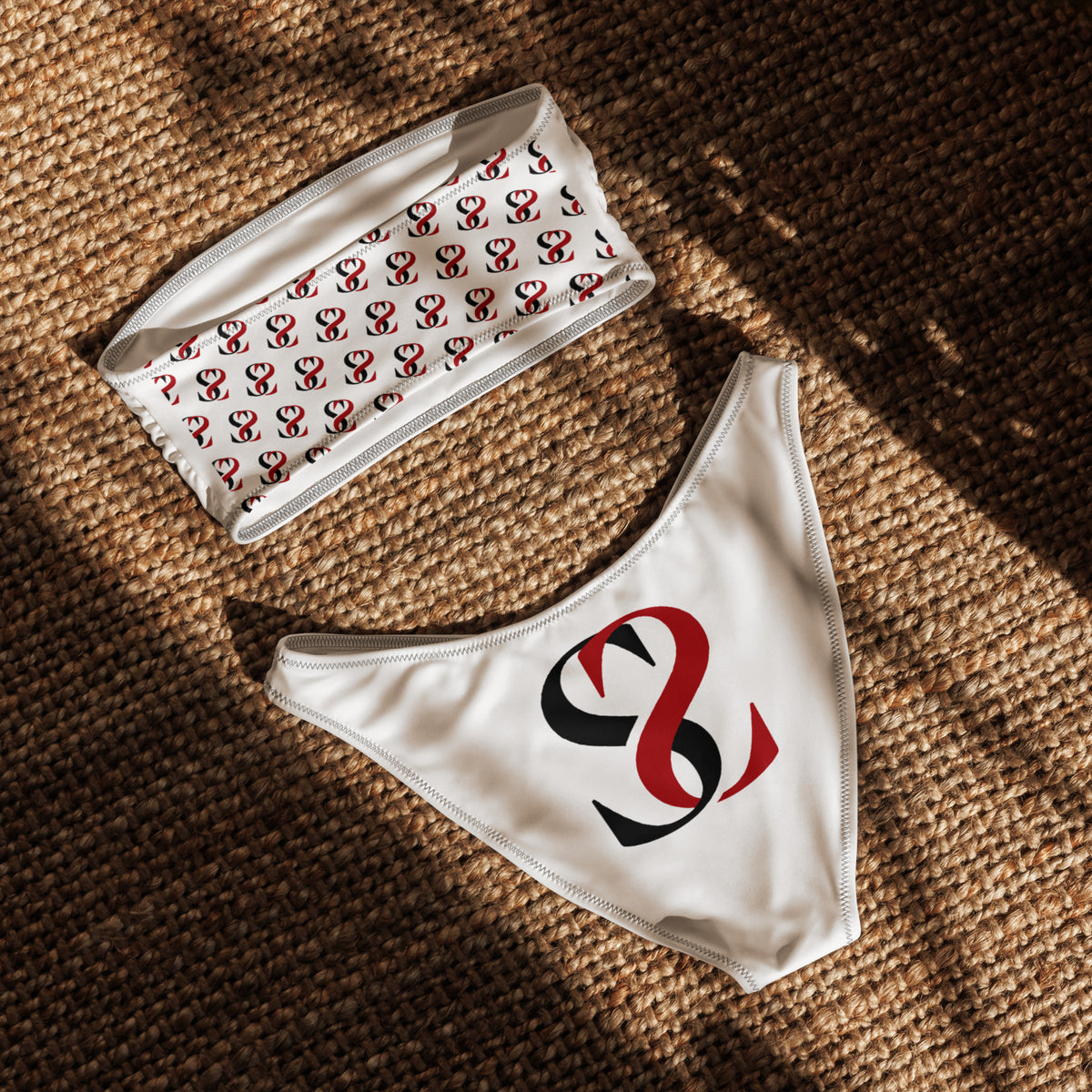Retro del bikini a fascia bianco Sick Story su un tappeto intrecciato, con motivo del logo sul top e grande logo nero e rosso sullo slip